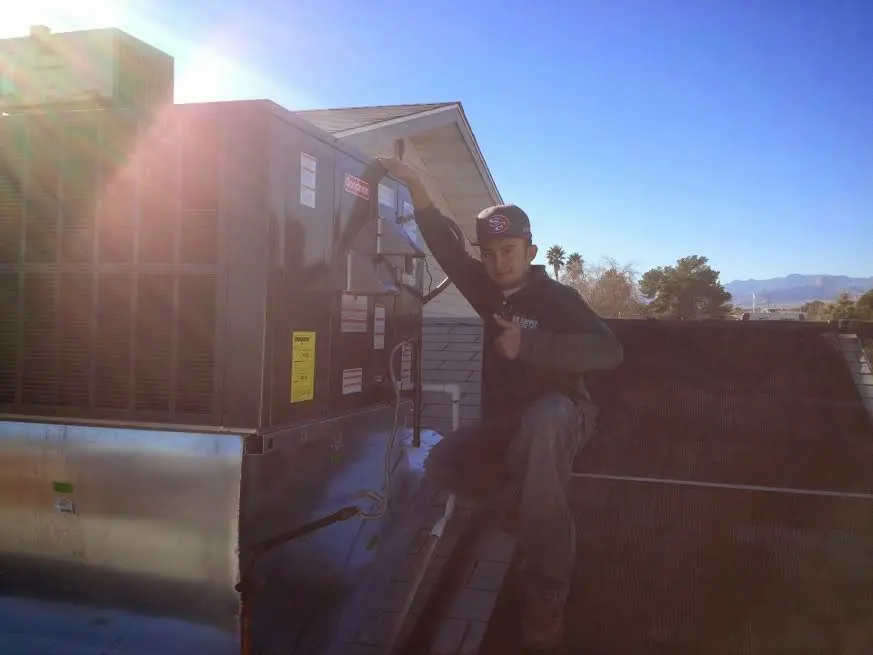 HVAC technician performing HVAC Inspection on a rooftop unit in Berthoud